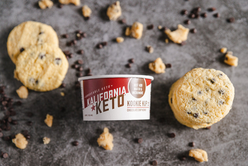 Keto Chocolate Chip Cookie Cup Surrounded by Cookies and Cookie Dough by Kalifornia Keto
