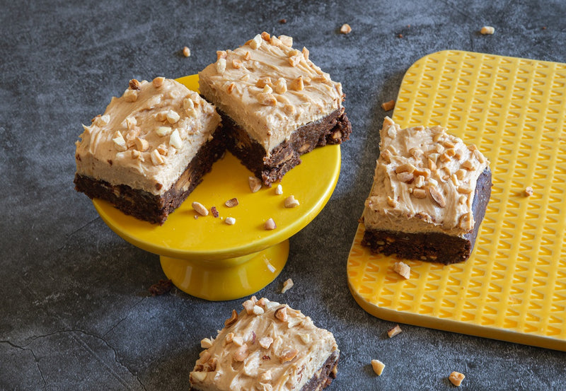 Peanut Butter Chocolate Keto No Bake Energy Bars Topped with Peanut Butter Frosting and Chopped Nuts
